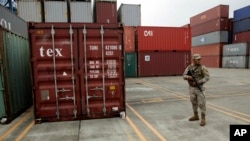 FILE - A police officer stands guard aboard the North Korean-flagged freighter Chong Chon Gang, at the Manzanillo International container terminal on the coast of Colon City, Panama, Wednesday, July 17, 2013. North Korea on Wednesday repeated Cuba's assertion th
