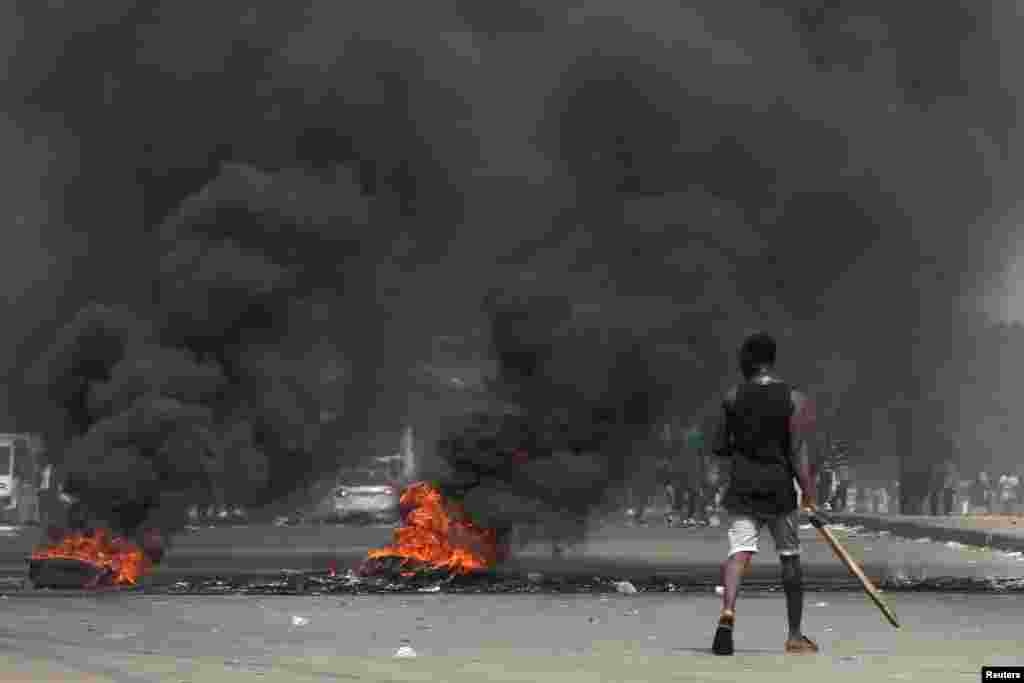 Anti-Gbagbo protesters block a street with burning tires after former Ivory Coast President Laurent Gbagbo was acquitted of all charges at the ICC war crimes court, in Abidjan&#39;s Abobo neighborhood, Ivory Coast.