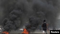 Anti-Gbagbo protesters block a street with burning tires after former Ivory Coast President Laurent Gbagbo was acquitted of all charges at the ICC war crimes court, in Abidjan's Abobo neighborhood, Ivory Coast, Jan. 16, 2019.