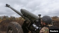 FILE PHOTO: Member of the Ukrainian National Guard prepares a D-30 howitzer for a fire towards Russian troops in Kharkiv region