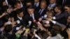 FILE - Reporters ring Brazil's President Jair Bolsonaro in Brasilia, May 7, 2019. Bolsonaro repeated a debunked sexually charged allegation about one of the nation’s prominent journalists on Feb. 18, 2020, drawing fire from press freedom advocates.