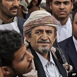 The head of the powerful Hashid tribe, Sheikh Sadique al-Ahmar, center, surrounded by guards, attends the funerals of tribesmen, who were killed in clashes with Yemeni security forces, in Sana'a, May 27, 2011.