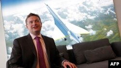 Boom Supersonic co-founder, Blake Scholl, poses in front of an artists impression of his company's proposed design for an supersonic aircraft, dubbed Baby Boom, at the Farnborough Airshow, south west of London, on July 18, 2018.
