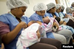 FILE - Mothers breastfeed their newborn babies in the natal intermediate care unit at the Santa Ana public maternity hospital in Caracas, Oct. 22, 2011.