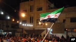 A handout picture released by the Syrian opposition's Shaam News Network shows a Syrian protester waving a pre-Baath Syrian flag during an anti-regime demonstration in Dael in the southern Daraa province late on April 12, 2012.