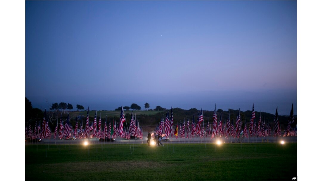 Visitors walk around the Pepperdine University's annual display of flags honoring the victims of the 9/11 terrorist attacks, Monday, Sept. 10, 2018, in Malibu, Calif.