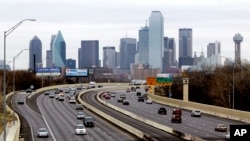 FILE - A view of Texas highway IH-30 traffic with the Dallas skyline. 
