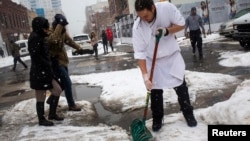 A man shovels snow in the Williamsburg neighborhood in the Brooklyn borough of New York, Feb. 15, 2014. 