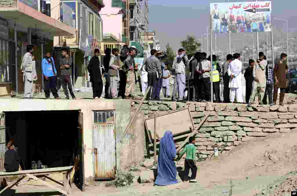 People observe the site of a suicide attack in the deputy counter-narcotic compound in Kabul, Afghanistan, Tuesday, July 22, 2014.&nbsp;