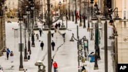 People walk through snow in downtown Madrid, Spain, Jan. 10, 2021 as a large part of central Spain including the capital Madrid are slowly clearing snow after the country's worst snowstorm in recent memory.