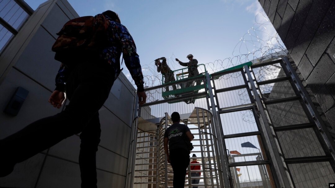 Marines install concertina wire, above, as pedestrians leave the United States for Mexico at the San Ysidro port of entry, Nov. 16, 2018, in San Diego.