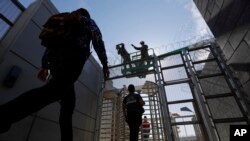 Marines install concertina wire, above, as pedestrians leave the United States for Mexico at the San Ysidro port of entry, Nov. 16, 2018, in San Diego.