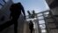 Marines install concertina wire, above, as pedestrians leave the United States for Mexico at the San Ysidro port of entry, Nov. 16, 2018, in San Diego.