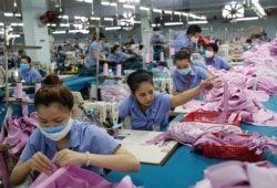 FILE- Laborers work at a garment assembly line of Thanh Cong textile, garment, investment and trading company in Ho Chi Minh city, Vietnam, July 9, 2019.