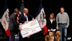 Donald Trump affichant un chèque émis au nom de sa fondation, le 30 janvier 2016.(AP Photo / Paul Sancya, Archives)