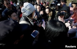 A parent is surrounded by members of the media outside the kindergarten run by preschool operator RYB Education Inc being investigated by China's police, in Beijing, China, Nov. 24, 2017.