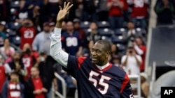 Ancien pivot de la NBA, Dikembe Mutombo les Texans de Houston sur le terrain avant un match de football de la NFL contre les Ravens de Baltimore dimanche, 21 décembre 2014, à Houston.