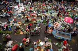 A crowd of people and vendors are seen at a market in Phnom Penh on February 1, 2021. (Photo by TANG CHHIN Sothy/AFP)