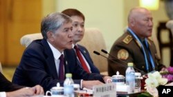 FILE - Kyrgyz President Almazbek Atambayev, left, talks with Chinese President Xi Jinping during a meeting at Diaoyutai State Guesthouse in Beijing, China, Sept. 2, 2015. 
