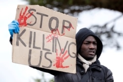 A demonstrator holds a placard during a Black Lives Matter protest in Watford, following the death of George Floyd who died in police custody in Minneapolis, Watford, Britain, June 6, 2020.