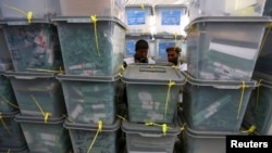 FILE - Afghan electoral workers sort ballot boxes at a counting center in Kabul. 