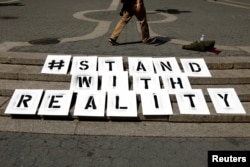 A sign used by a small group of demonstrators rests on steps during a demonstration to support intelligence contractor, Reality Leigh Winner, after she was charged with leaking classified documents, June 7, 2017.