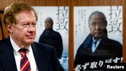 Robert King, U.S. special envoy for North Korean human rights issues, stands in front of campaign posters of Japan's abduction issue during a meeting with Japan's Minister-in-Charge of the Abduction Issue and head of the national public safety commission Keiji Furuya (not in picture) in Tokyo August 28, 2013. 