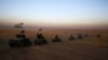 FILE - In this Oct. 17, 2016 file photo, a Kurdish peshmerga convoy drives towards a frontline in Khazer, about 30 kilometers east of Mosul, Iraq. 