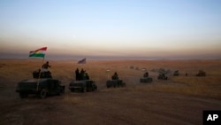 FILE - In this Oct. 17, 2016 file photo, a Kurdish peshmerga convoy drives towards a frontline in Khazer, about 30 kilometers east of Mosul, Iraq. 