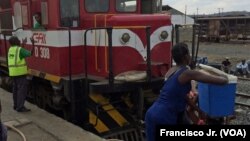 Uma mulher coloca uma mala na cabeça de outra na estação de Caminhos de Ferro de Moçambique, em Moatize