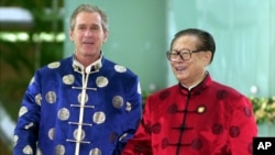 2001年10月21日，时任美国总统布什与时任中国国家主席江泽民身穿丝绸服装出席APEC上海峰会。（美联社）