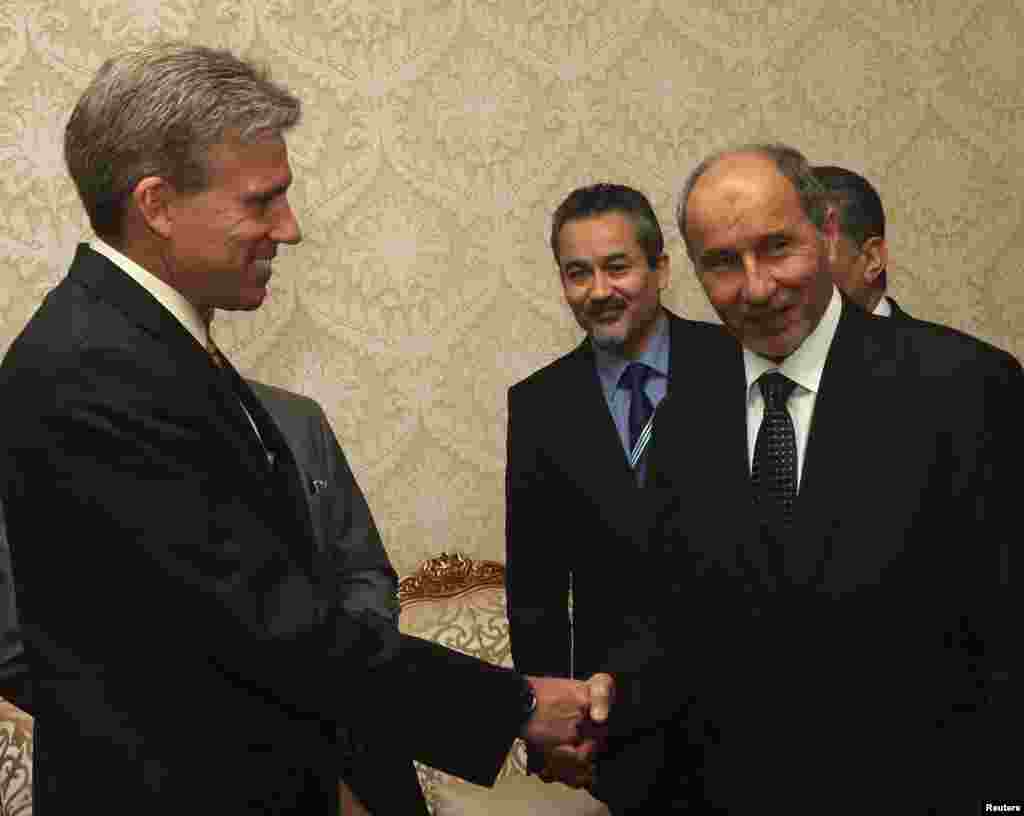 John Christopher Stevens (kiri), Dubes AS untuk Libya, berjabat tangan dengan Ketua Dewan Transisi Nasional Libya (NTC), Mustafa Abdel Jalil setelah menyerahkan kredensial sebagai Dubes baru AS untuk Tripoli (7 Juni 2012).