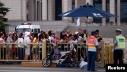 Visitors queue for a security check to enter Tiananmen Square in Beijing, June 4, 2014.