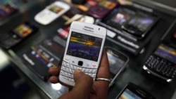 A customer holds a BlackBerry handset inside a mobile selling shop in Kolkata August 12, 2010. REUTERS/Rupak De Chowdhuri