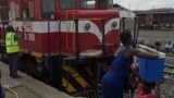 Uma mulher coloca uma mala na cabeça de outra na estação de Caminhos de Ferro de Moçambique, em Moatize