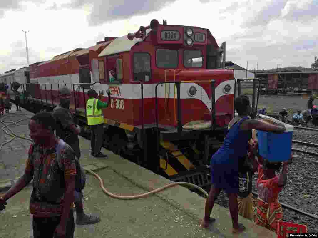 Uma mulher coloca uma mala na cabeça de outra na estação de Caminhos de Ferro de Moçambique em Moatize