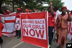 FILE - People attend a demonstration calling on the government to rescue the kidnapped girls of the government secondary school in Chibok, in Abuja, Nigeria, Oct. 14, 2014.