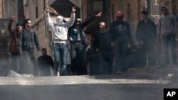 Anti-Syrian government protesters flash Victory signs as they protest in the southern city of Daraa, March 23, 2011.