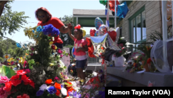 Une famille vient rendre au hommage au boxeur à 3302 Grand Ave, à Louisville, Kentucky le 9 juin 2016, la maison où Mohamed Ali a grandi de 1947 à 1961.