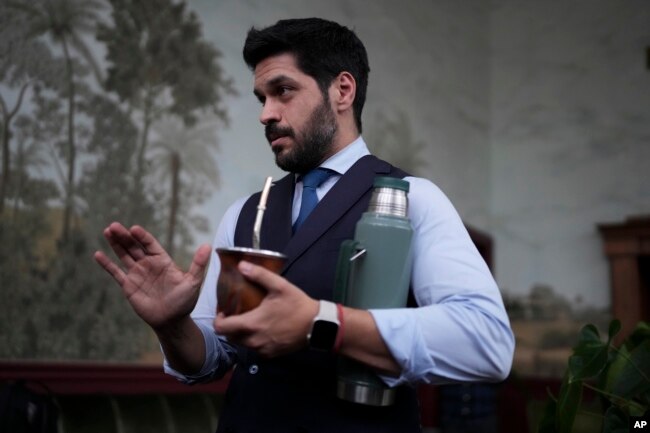 El candidato presidencial del Partido Colorado, Andrés Ojeda, toma mate mientras habla con la prensa antes de las elecciones generales en Montevideo, Uruguay, el miércoles 23 de octubre de 2024. (Foto AP/Matilde Campodonico)