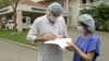 Lucien Blanchard, general manager of the Vietnam-France Hospital, signs a form for a nurse outside the facility in capital city Hanoi, March 2003.