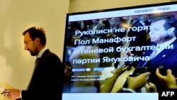 FILE - Member of Ukraine's parliament and former journalist Serhiy Leshchenko holds papers in front of a screen displaying a picture of Donald Trump's former presidential campaign chairman Paul Manafort during a press conference in Kyiv, Ukraine, Aug. 19, 2016.