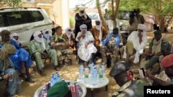 FILE - A delegation of Malian, French and UN army officers greet separatist rebel patriarch Intallah Ag Attaher (C, in white) in Kidal, June 23, 2013.