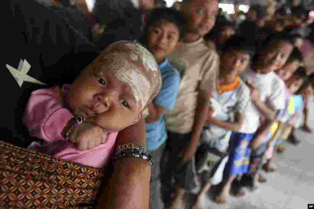 Villagers, who were affected by volcanic ash from the Mt. Sinabung eruption, form a long line to pick up donations in Batu Karang, North Sumatra, Indonesia. The rumbling volcano in western Indonesia continues unleashing fresh clouds of searing gas. 