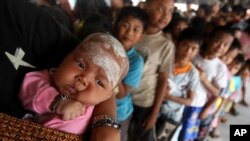 Para pengungsi yang terkena dampak letusan Gunung Sinabung, antre untuk mendapatkan donasi di Batu Karang, Sumatera Utara (9/2).