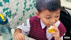 A lad  tries his archetypal  escaped  repast  astatine  Susukan nationalist   simple  schoolhouse  successful  Jakarta, Indonesia. (Devianti Faridz/VOA)