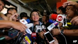Maria Ressa, center, the award-winning head of a Philippine online news site Rappler, talks to reporters after posting bail at a Regional Trial Court following an overnight arrest by National Bureau of Investigation agents on a libel case Thursday, Feb. 14, 2019 in Manila. 