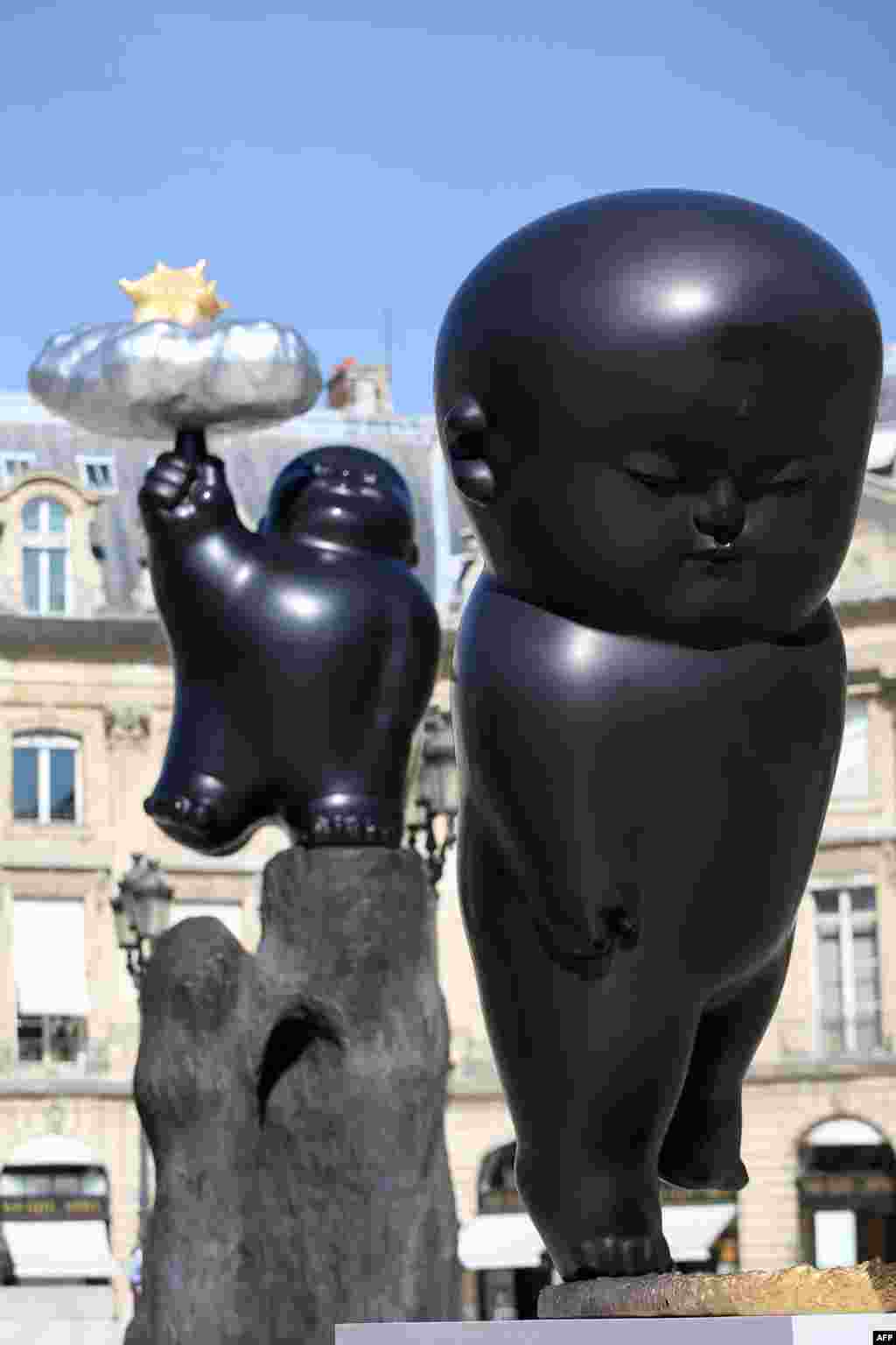 A picture taken at the place Vendome in Paris shows Taiwanese artist Li Chen&#39;s sculptures &#39;Floating Heavenly Palace&#39; and &#39;Flickering Moonlight&#39; (R).