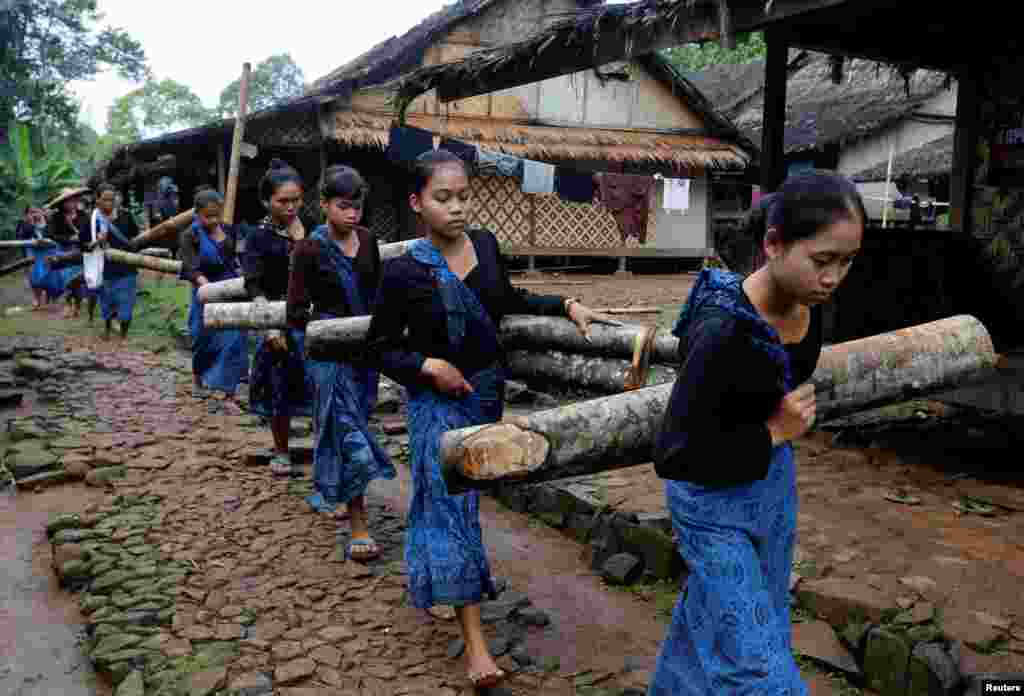 ស្រ្តី​ជនជាតិ​​ Baduy ក្នុង​ប្រទេស​ឥណ្ឌូណេស៊ី​សែងឈើ​ពេល​កំពុង​ដើរ​នៅ​ខាងមុខ​ស្ថានីយ៍​បោះឆ្នោត​មួយ​សម្រាប់​ការ​បោះឆ្នោត​ជាតិ​នៅ​ក្នុង​ភូមិ Kanekes village ក្រុង Rangkasbitung ខេត្ត Banten ប្រទេស​ឥណ្ឌូណេស៊ី​។