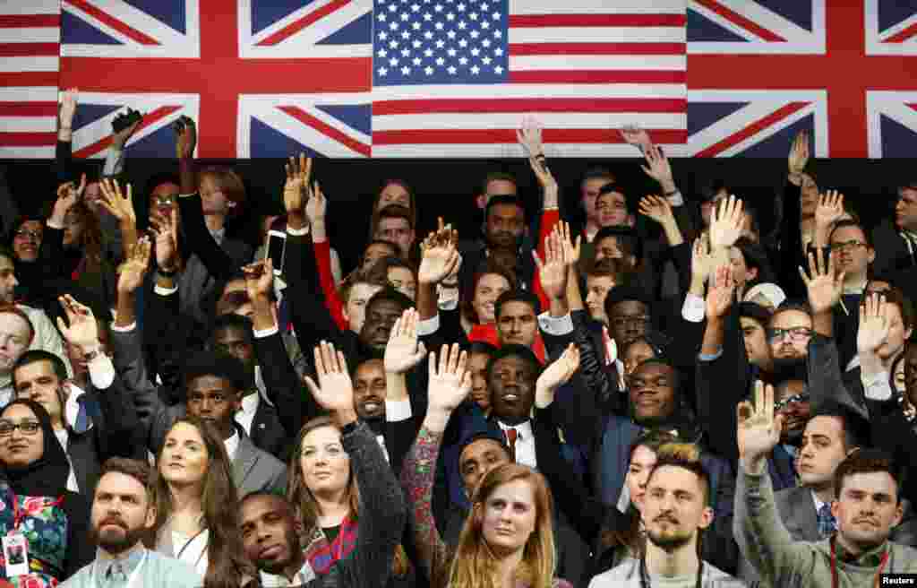 Para mahasiswa mengacungkan tangannya untuk bertanya kepada Presiden AS Barack Obama dalam pertemuan di Royal Agricultural Halls, London (23/4). (Reuters/Kevin Lamarque)